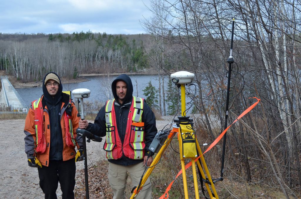 Deux arpenteurs de Denicourt devant un plan d'eau