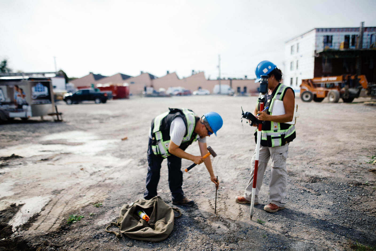 deux travailleurs en arpentage qui pique un terrain